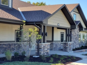 "Upendo House" assisted living facility exterior image depicting a suburban house in Shawnee, Kansas, with a modern, rustic design, a paved pathway, and a small front garden.